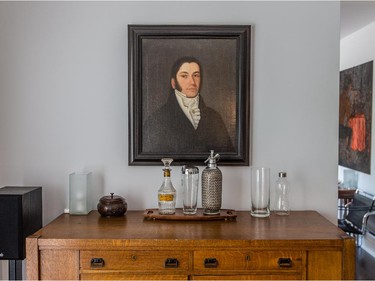 An oil painting of an ancestor hangs over the bar in the dining room in Dubreuil's condo. (Dario Ayala / Montreal Gazette)