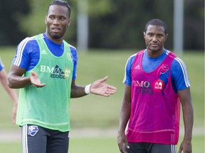 Montreal Impact player Didier Drogba (in green vest) talks with teammate Patrice Bernier as the Impact practised in Montreal Thursday, Aug. 6, 2015. (John Kenney / MONTREAL GAZETTE)