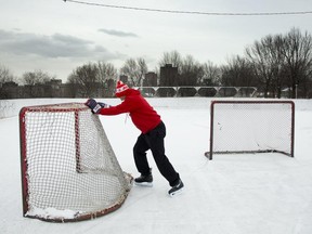 Gasper Gasperlin uses a hockey net to remove snow from the ice at the rink at at Jeanne Mance Park by Mount Royal on Jan. 20, 2014.