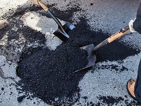 MONTREAL, QUE.: MARCH 14, 2011-- City workers Johanne Tessier (R) and a co-worker (L)put down fresh asphalt to cover potholes on Ontario street near Plessis street in Montreal on Monday, March 14, 2011. (Dario Ayala/THE GAZETTE)