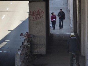 A cyclist uses the sidewalk at a St-Denis St. underpass.