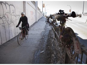 A cyclist uses the sidewalk at the St-Denis St. underpass at des Carrieres St.