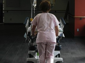 A nurse wheels a patient at the Ambulatory Care Centre at Maisonneuve Rosemont in Montreal.