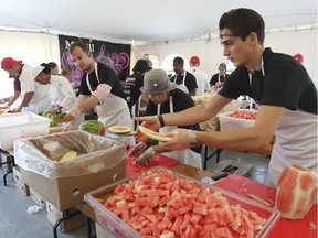Volunteers chop melons and watermelon as McGill University faculty and students try to set a world record for the largest smoothie in Montreal on Tuesday, Sept. , 2015.