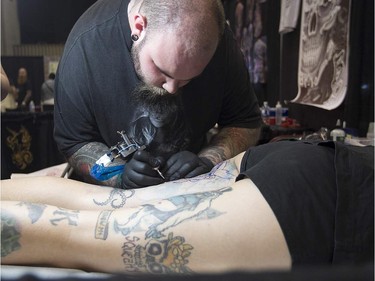 Tatoo artist Jean-Francois Trudel puts down his art on Michelle Ayoub, during art tattoo show in Montreal on Friday September 11, 2015. The show at Place Bonaventure goes on through the weekend.