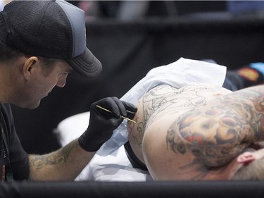 Tatoo artist Rob Noseworthy puts down his art on Mike Connors during art tattoo show in Montreal on Friday September 11, 2015. The show at Place Bonaventure goes on through the weekend.