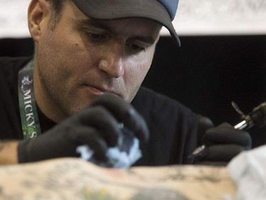 Tatoo artist Rob Noseworthy puts down his art on Mike Connors during art tattoo show in Montreal on Friday September 11, 2015. The show at Place Bonaventure goes on through the weekend.