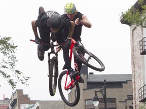 Riders occupy the same air space on St-Laurent Blvd. in Montreal on Saturday, Sept. 12, 2015, on the second and final day of the Mud Rocker BMX/mountain bike competition.