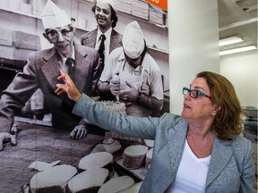 Gail Cantor at the family bakery in Montreal, on Friday, Sept. 18, 2015. The bakery is celebrating its 60th year in business. Grandfather Sam Cantor, father Max Cantor and head baker Frank Palermo, left to right in a photo hanging at the bakery.