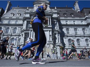 Runners pass Montreal city hall during the Montreal Marathon on Sunday Sept. 20, 2015.