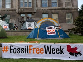 A pedestrian walks past the Community Square at McGill University where Divest McGill set up a camp in Montreal on Monday September 21, 2015. The group is demanding that the university divest from fossil fuel companies.