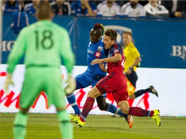 Chicago Fire defender Patrick Doody, right, leans on Montreal Impact forward Dominic Oduro as he makes a drive towards Chicago Fire goalkeeper Jon Busch during MLS action at Saputo Stadium in Montreal on Wednesday September 23, 2015.