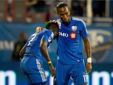 Montreal Impact forward Didier Drogba, right, consoles Montreal Impact forward Dominic Oduro after Oduro was knocked to the turf during a drive to the Chicago Fire net during MLS action at Saputo Stadium in Montreal on Wednesday September 23, 2015.