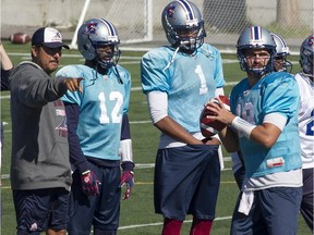 Montreal Alouette quarterback Jonathan Crompton, right, with teammates Rakeem Cato (12), and Brandon Bridge (1), with quarterback coach Anthony Calvillo, during practice in Montreal on Thursday, Sept. 24, 2015.