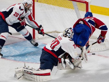 Montreal Canadiens centre Alex Galchenyuk is tripped up by Washington Capitals goalie Braden Holtby during NHL pre-season action in Montreal on Thursday September 24, 2015. Washington Capitals defenceman Ryan Stanton covers the open net.