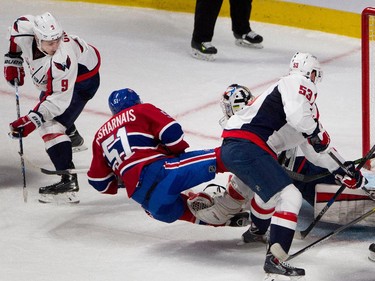 Washington Capitals defenceman Dmitry Orlov, left, looks back to watch Montreal Canadiens centre David Desharnais score against Washington Capitals goalie Braden Holtby during NHL pre-season action in Montreal on Thursday September 24, 2015. Washington Capitals centre Sean Collins, right, looks on.