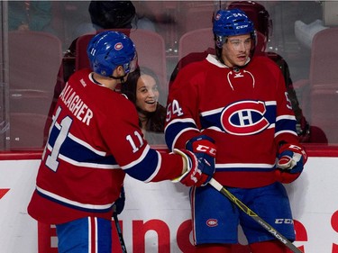 A young fan is all smiles as Montreal Canadiens right wing Brendan Gallagher, left, pushes Montreal Canadiens left wing Charles Hudon into the boards during the pre-game skate against the Chicago Blackhawks during NHL pre-season action in Montreal on Friday September 25, 2015.