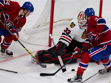 Chicago Blackhawks goalie Scott Darling pulls in the loose puck as Montreal Canadiens left wing Charles Hudon, left, and Montreal Canadiens right wing Zack Kassian try to get to the puck during NHL pre-season action in Montreal on Friday September 25, 2015.