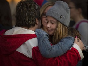 Élodie  Bourget closes her eyes as she relaxes in her mothers' arms when she was finally allowed to leave the Cegep de Valleyfield, west of Montreal, after spending 4 hours in lockdown when a report of a man entering the school with a gun brought police to the school on Friday, September 25, 2015.