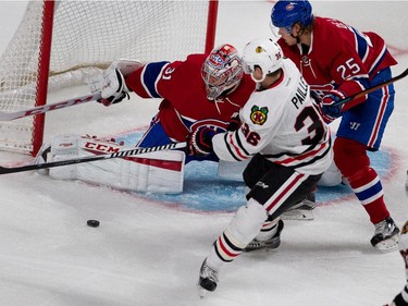 Montreal Canadiens goalie Carey Price makes a save as Montreal Canadiens left wing Jacob De La Rose, right, tries to clear Chicago Blackhawks left wing Daniel Paillé from the goal crease during NHL pre-season action in Montreal on Friday September 25, 2015.