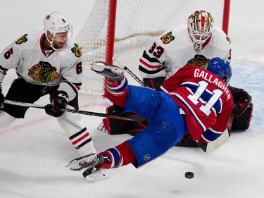 Montreal Canadiens right wing Brendan Gallagher gets tripped up by Chicago Blackhawks defenceman Trevor Daley as he takes a shot on Chicago Blackhawks goalie Scott Darling during NHL pre-season action in Montreal on Friday September 25, 2015.