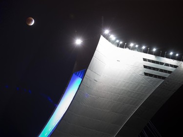 A total eclipse of the moon hangs over the Olympic Stadium  in Montreal, Sunday Sept. 27, 2015.