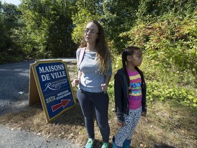 Laura Gauthier and her daughter Jerrikah on the outside of the wooded area that is starting to see development on Don Quichotte Blvd. in Notre-Dame- de-l'Ile-Perrot. They take regular walks into the wooded area that has a marsh and an abundant wildlife system and is concerned about the loss of green space. (Peter McCabe / MONTREAL GAZETTE)