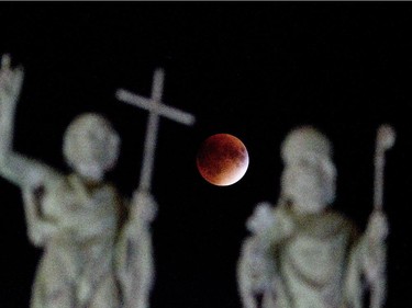 The perigee full moon, or "supermoon," appears red behind Mary Queen of the World catherdral in Montreal, Sunday September 27,  2015.  The combination of a supermoon and total lunar eclipse last occurred in 1982 and will not happen again until 2033.