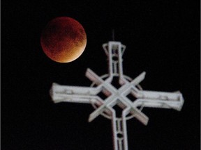 The perigee full moon, or "supermoon," appears red behind Mary Queen of the World catherdral in Montreal, Sunday Sept. 27,  2015.