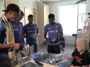 Ten year-old Brandon Houle is surrounded by Impact soccer players, including Didier Drogba, far left, Ambroise Oyongo, back right, Calum Mallace, left centre, and Dilly Duka as they visit the kids at Ste- Justine hospital on Tuesday September 29, 2015.