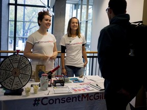 Consent McGill member Alice Gauntley, left, and Bianca Tetrault, liasion officer for the Office of the Dean of Students speak with a student as he passes their table in the Brown Building at McGill University in Montreal on Wednesday Sept. 30, 2015.