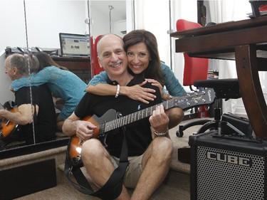 Richard Andrews and his wife Marie Cordeau pose for a photograph on the third floor of their condo where he plays guitar occassionnally.