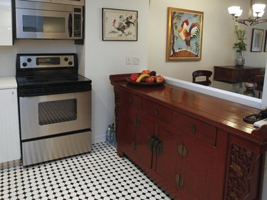 The red Chinese antique furniture contrasts with the immaculate white in the renovated kitchen.