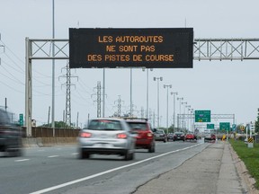 Cars travelling east on Highway 20, pass a Transport Quebec electronic sign near Sources Road in Dorval.