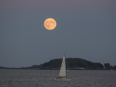 The Super Blood Moon rises over a sailboat in Boston Harbor on Sept. 27, 2015 in Boston, Massachusetts.