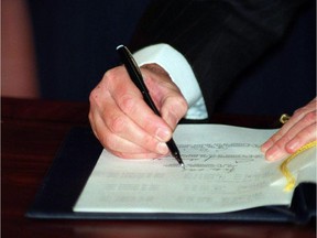 Prime Minister Brian Mulroney signs the North American Free Trade Agreement during a signing ceremony in Ottawa, Dec.17, 1992.