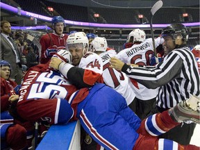 Ottawa Senators forward Travis Ewanyk dumps Canadiens forward Brendon McNally into the Montreal bench as several fights break out at the end of the first period during their NHL Rookie Tournament game at Budweiser Gardens in London, Ont. on Sept. 13, 2015.