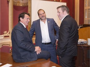Quebec Opposition Leader Pierre-Karl Peladeau, left, chats with Opposition party caucus members Pascal Berube, right and Harold LeBel, centre, at the beginning of caucus meeting, Wednesday, Sept. 9, 2015 at the legislature in Quebec City.