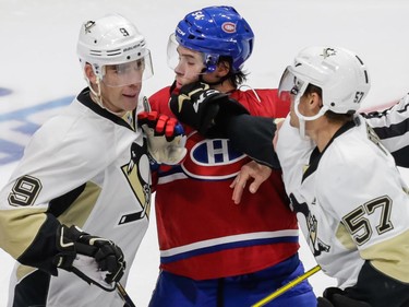 Montreal Canadiens left wing Charles Hudon is punched by Pittsburgh Penguins left wing David Perron, right, as Penguins right wing Pascal Dupuis, left, looks on during the second period of their preseason NHL match at the Centre Vidéotron Centre in Quebec City on Monday, Sept. 28, 2015.