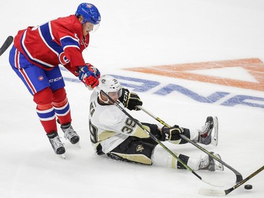 Pittsburgh Penguins centre Jean-Sabastien Dea, falls after being tripped by Montreal Canadiens centre Lars Elle during the first period of their preseason NHL match at the Centre Vidéotron  in Quebec City on Monday, Sept. 28, 2015.