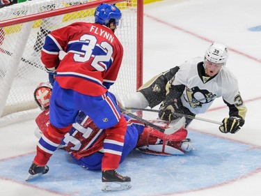 Pittsburgh Penguins centre Jean-Sabastien Dea falls after colliding with Montreal Canadiens goalie Carey Price as Montreal Canadiens right wing Brian Flynn looks on during the second period of their preseason NHL match at the Centre Vidéotron in Quebec City on Monday, Sept. 28, 2015.