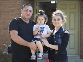Saifan Istefan of Iraq and his wife, Talar Donian, of Syria stand with their two-year-old son, Zenos, outside the home provided by King's University College which has sponsored their move to Canada, in London, Ont., on Wednesday Sept. 16, 2015.