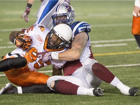 Montreal Alouettes' Gabriel Knapton, right, tackles B.C. Lions' Shawn Gore during second half CFL football action in Montreal on Thursday, September 3, 2015.