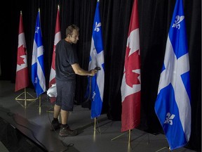 Technician Mike Sorowka steams wrinkles from the flags before NDP leader Tom Mulcair addresses supporters during a campaign stop in Montreal on Wednesday, Sept. 23, 2015.