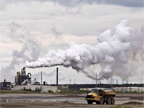 FILE -- A dump truck works near the Syncrude oil sands extraction facility near the town of Fort McMurray, Alberta on Sunday June 1, 2014. The furore over a New Democrat candidate's remarks about leaving a lot of Alberta's oilsands in the ground is a reflection of how poorly the issue is understood, say energy experts.