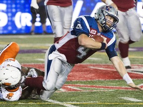 Montreal Alouettes' quarterback Tanner Marsh, right, is sacked by B.C. Lions' Alex Bazzie during second half CFL football action in Montreal on Thursday, September 3, 2015.