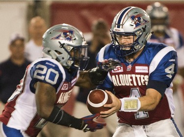 Montreal Alouettes' quarterback Tanner Marsh, right, hands off to Tyrell Sutton during first half CFL football action against the B.C. Lions in Montreal on Thursday, September 3, 2015.