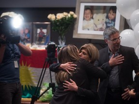Tima Kurdi, centre right, aunt of late brothers Alan and Ghalib Kurdi, is embraced by a woman during a memorial service for the boys and their mother, as her husband Rocco Logozzo, right, stands by in Vancouver, B.C., on Saturday, Sept. 5, 2015. The body of three-year-old Syrian Alan Kurdi was found on a Turkish beach after the small rubber boat he, his five-year old brother, Ghalib, and their mother, Rehanna, were in capsized during a desperate voyage from Turkey to Greece.