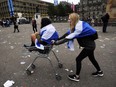 Pro-independence supporters push each other in a shopping trolley in Glasgow, Scotland, on September 19, 2014, following a defeat in the referendum on Scottish independence.