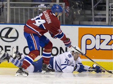 Toronto Maple Leafs forward Frederik Gauthier slides along the ice and he and Montreal Canadiens forward Michael McCarron reach for the puck during their NHL Rookie Tournament hockey game at Budweiser Gardens in London, Ont., on Saturday, September 12, 2015.